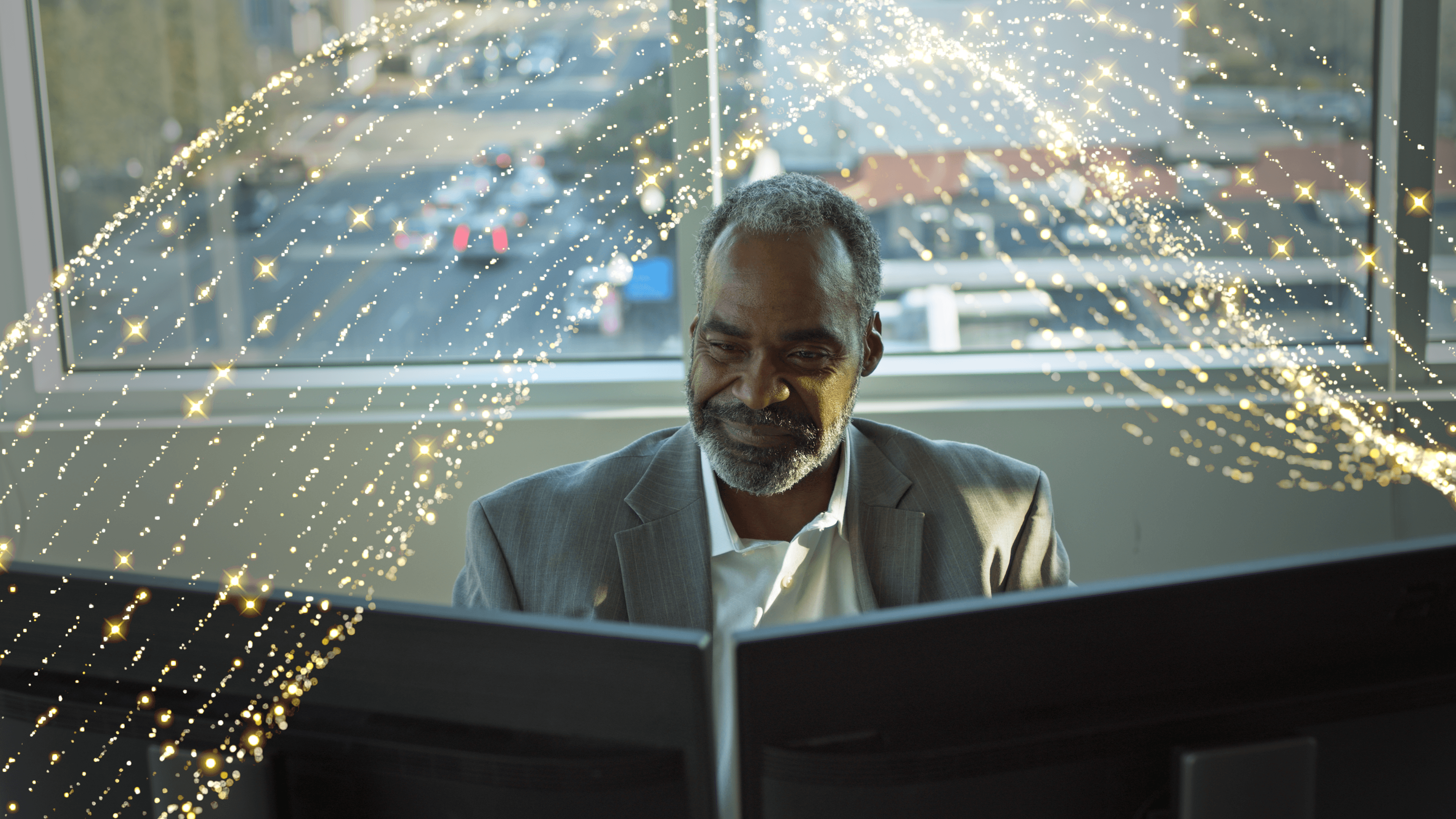 Professional man siting at computer with gold waves about him