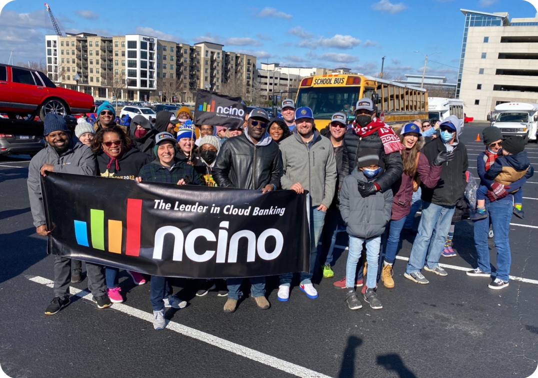 Employees hold a nCino banner at a local Martin Luther King Junior Day parade in the cold. 