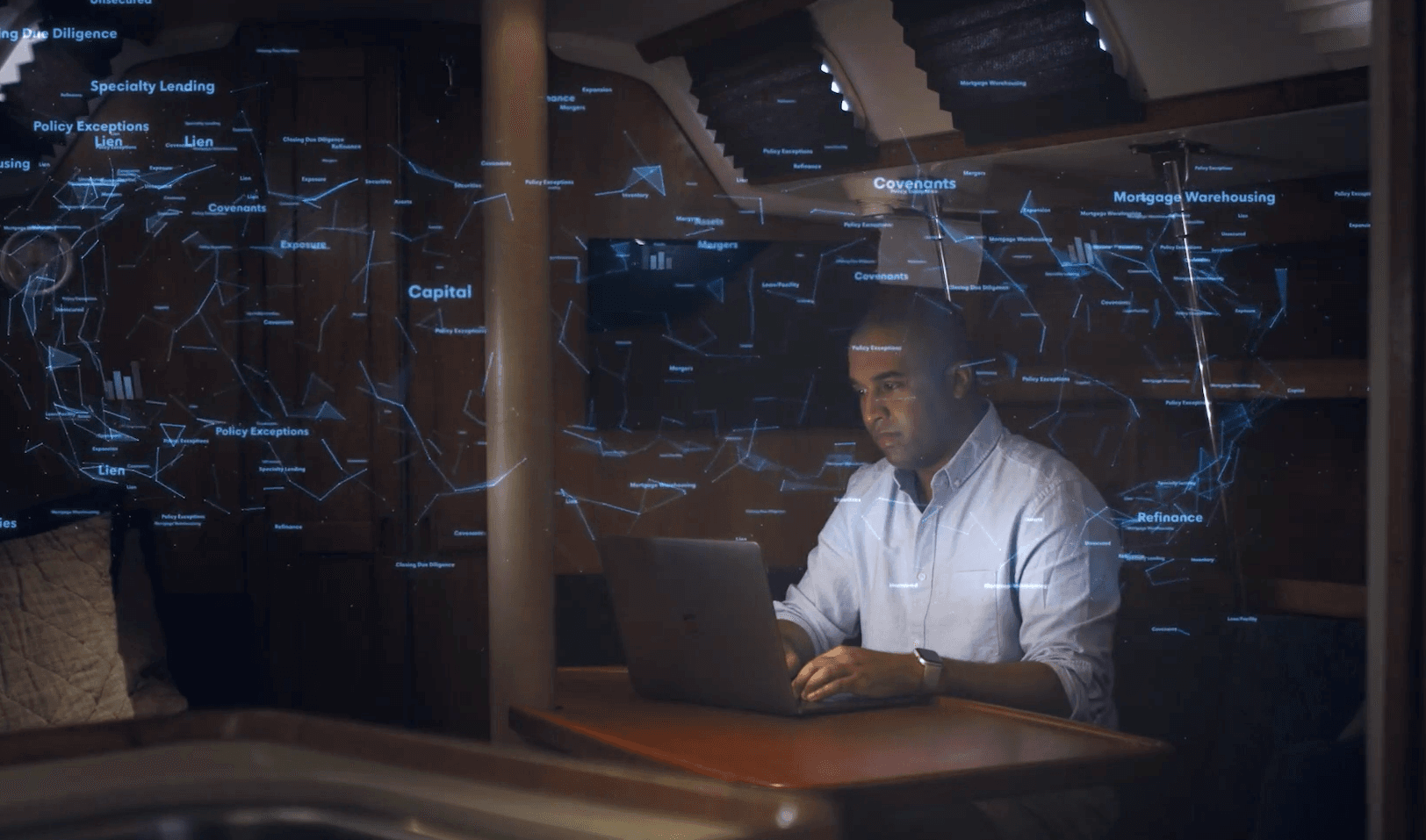 A man sits at a desk at night with numbers and equations floating around him while he works. 