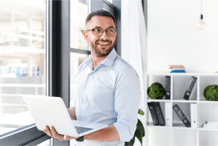 man-blue-shirt-holding-laptop