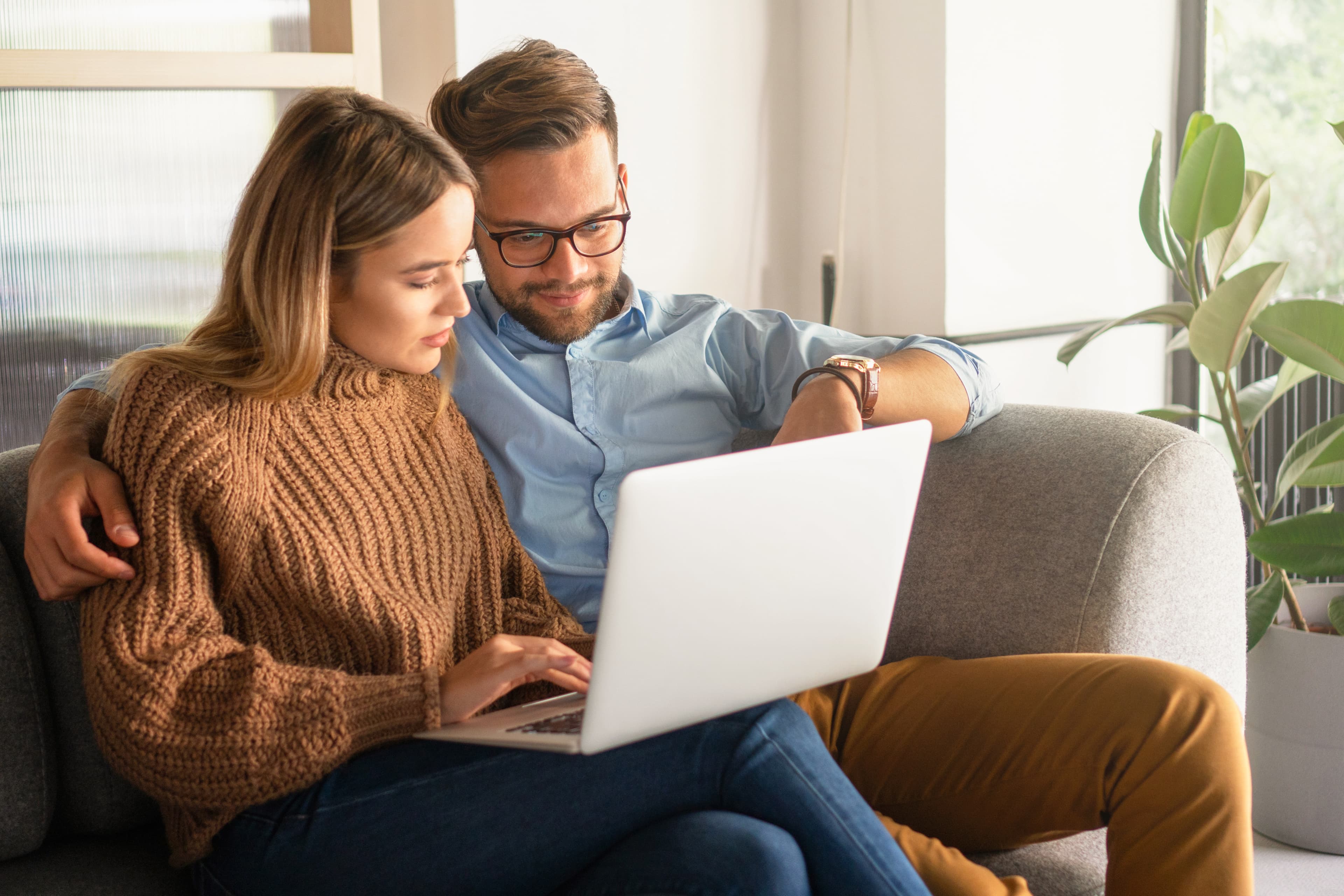 Mortgage-Couple Using Laptop on Couch at Home